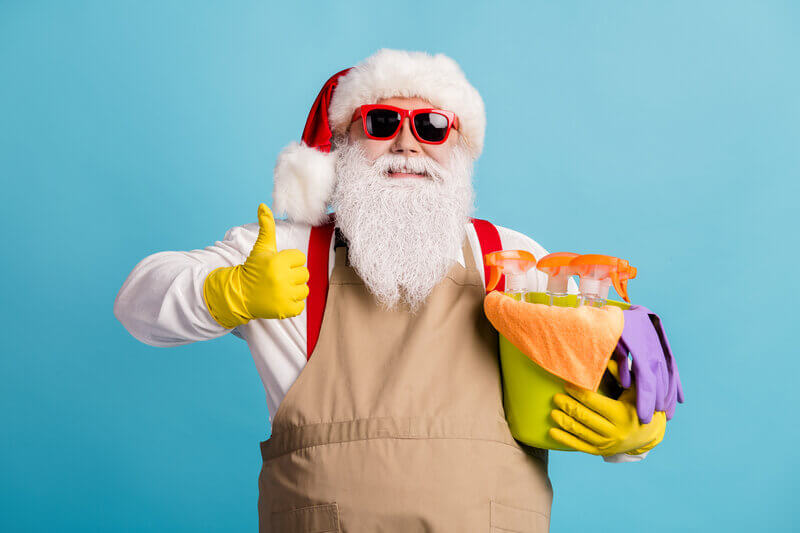 Christmas cleaning with Santa holding a bucket full of supplies.